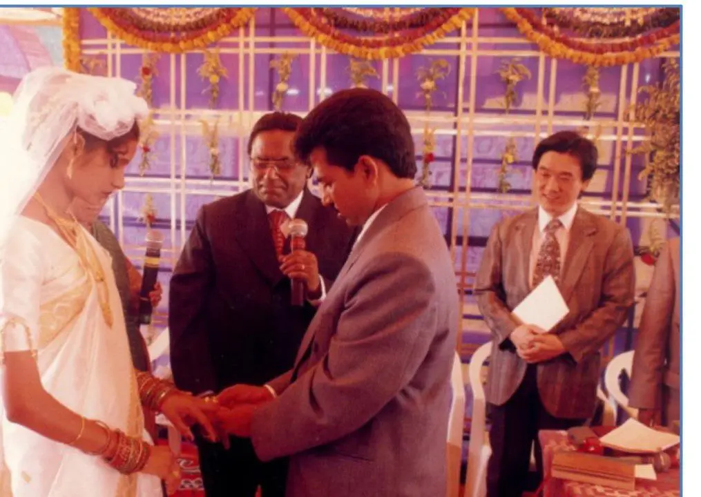 A man and woman exchanging wedding rings at an event.