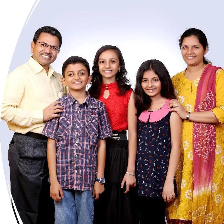 A family posing for the camera in front of a white background.