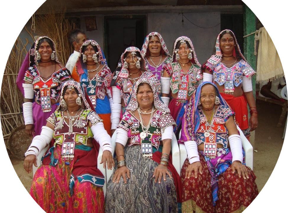 A group of women in colorful outfits posing for the camera.