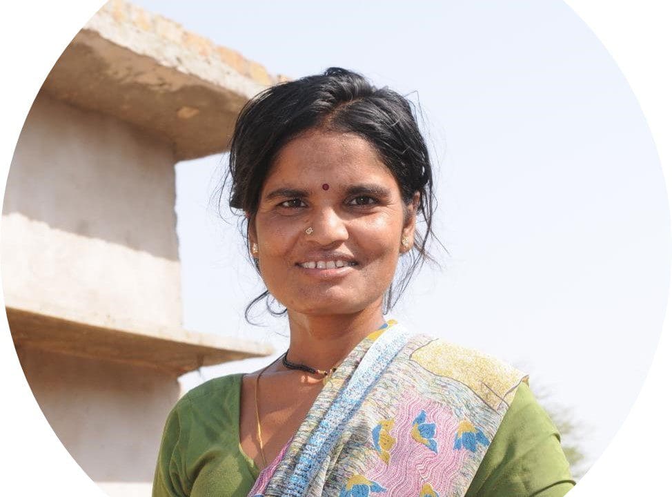 A woman in green shirt smiling for the camera.