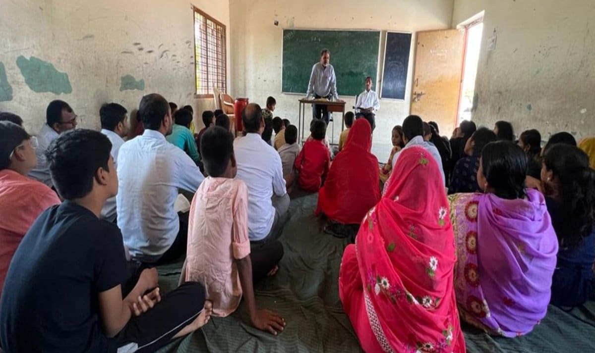 A group of people sitting in front of a man.