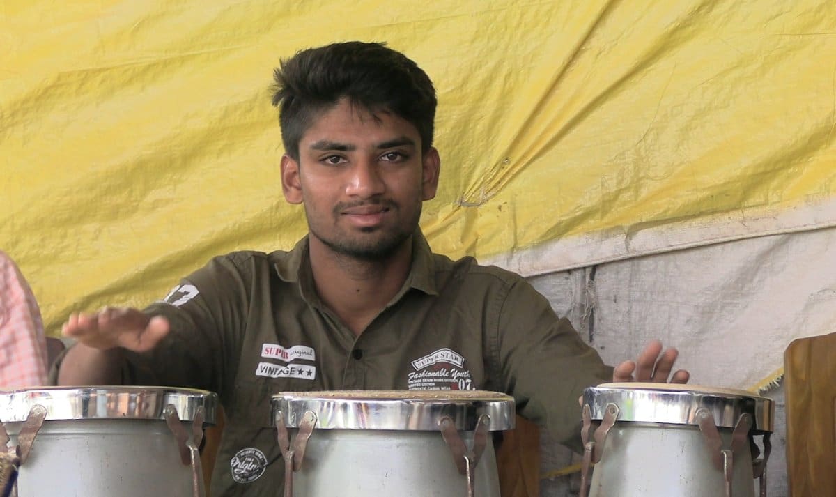 A man is holding some pots and smiling.