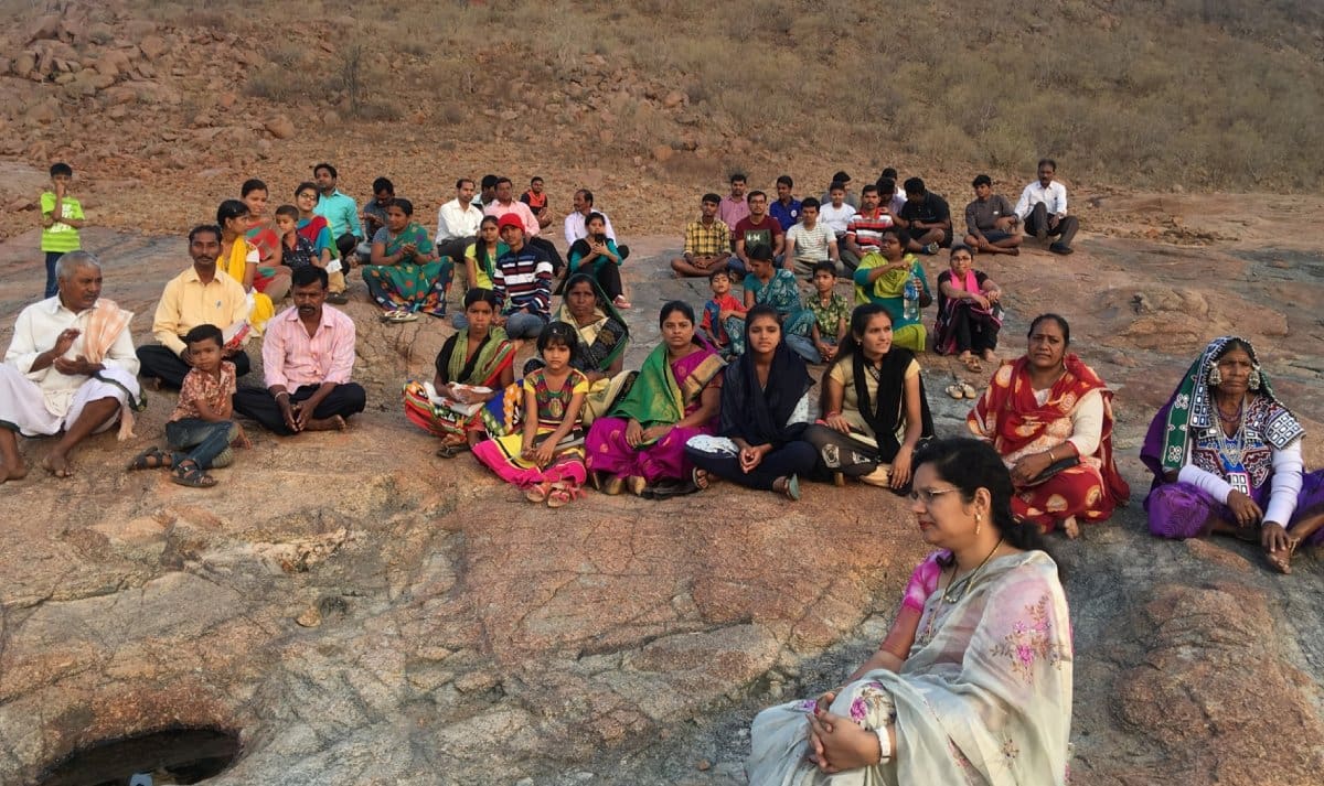 A group of people sitting on top of a mountain.