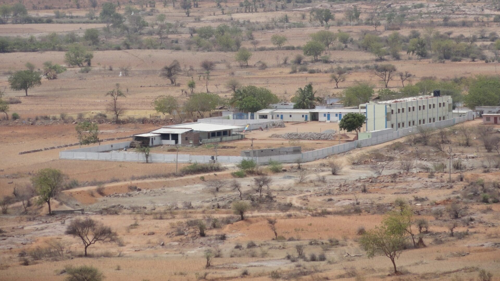 A view of a desert with houses and trees.