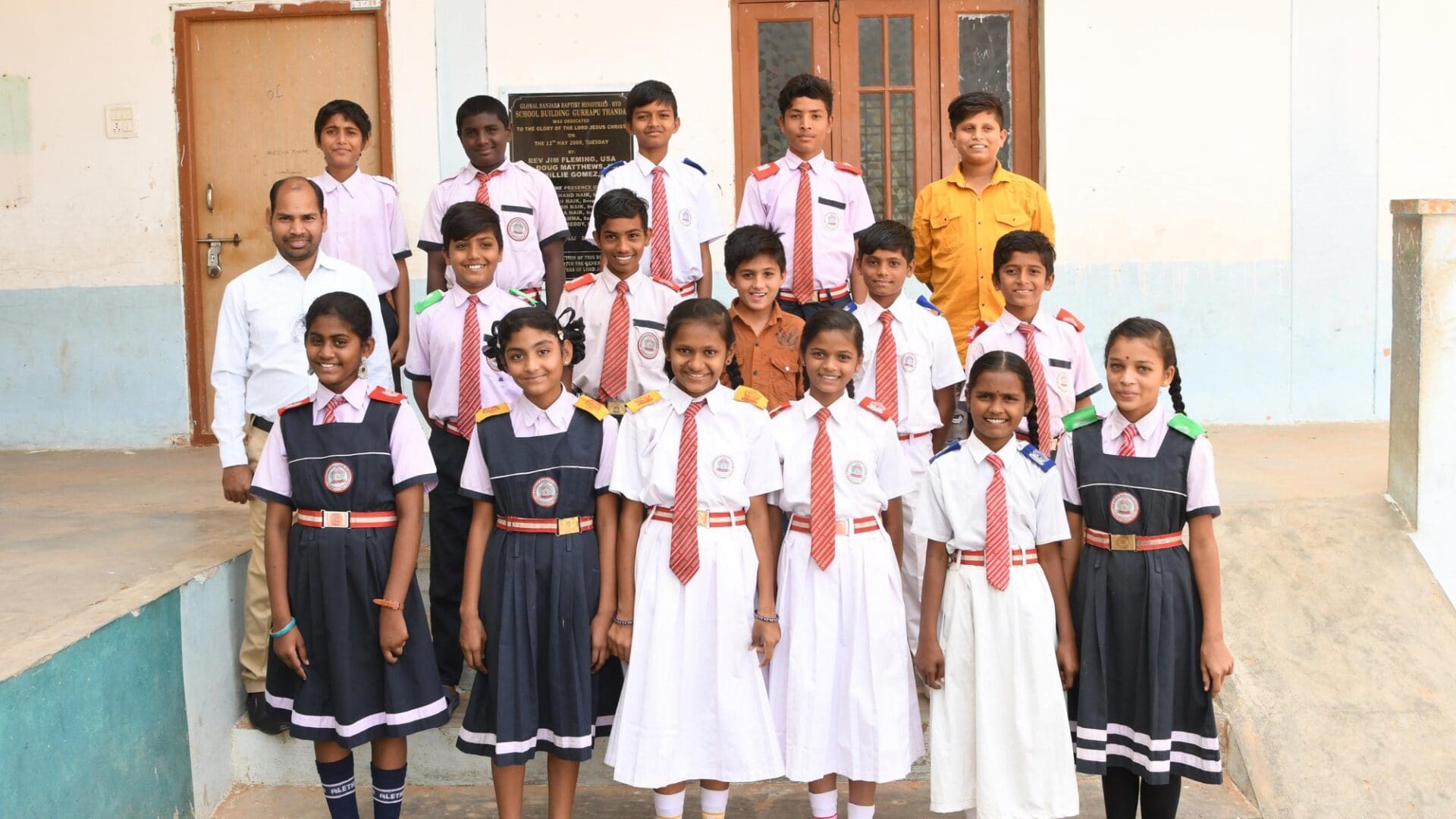 A group of children standing in front of a building.