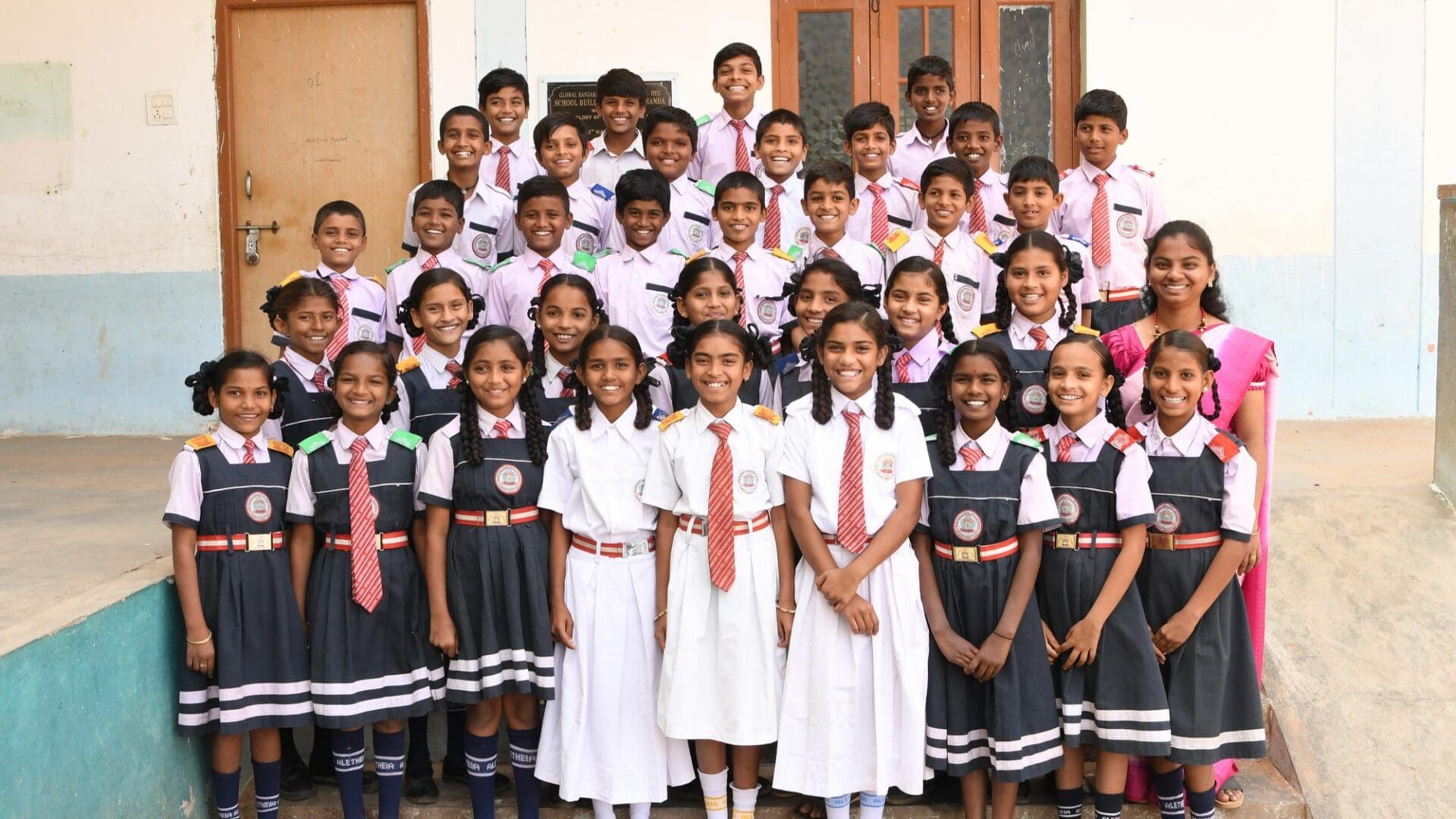 A group of children in school uniforms posing for the camera.