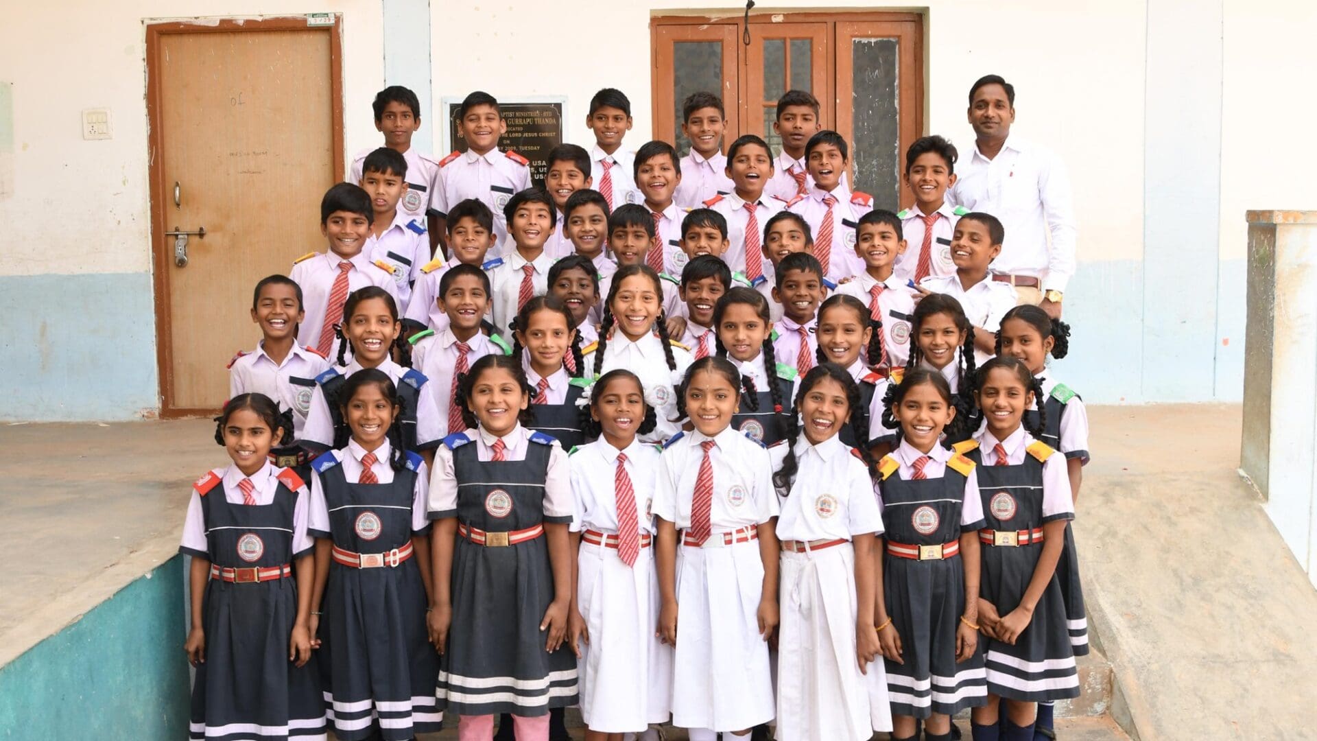 A group of children standing in front of a building.