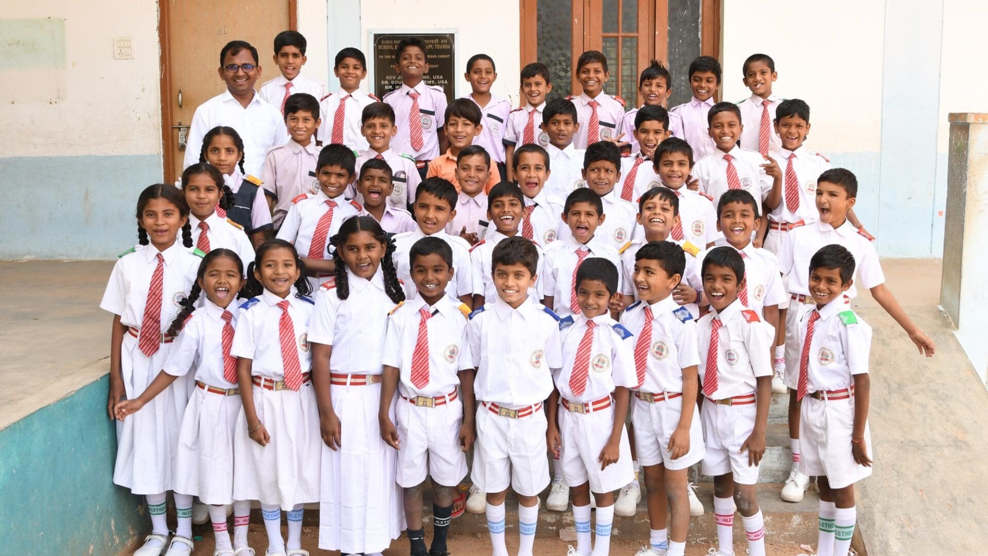 A group of children in white uniforms and ties.