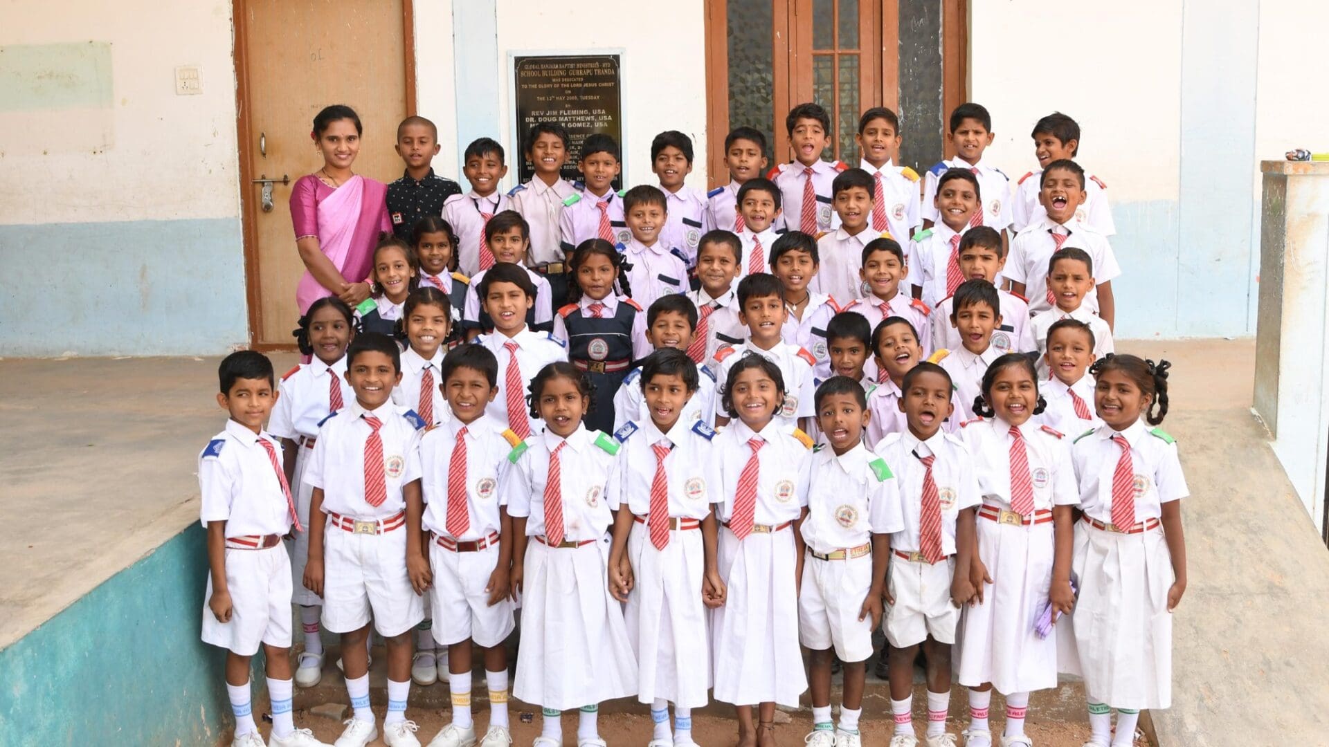 A group of children in school uniforms posing for the camera.