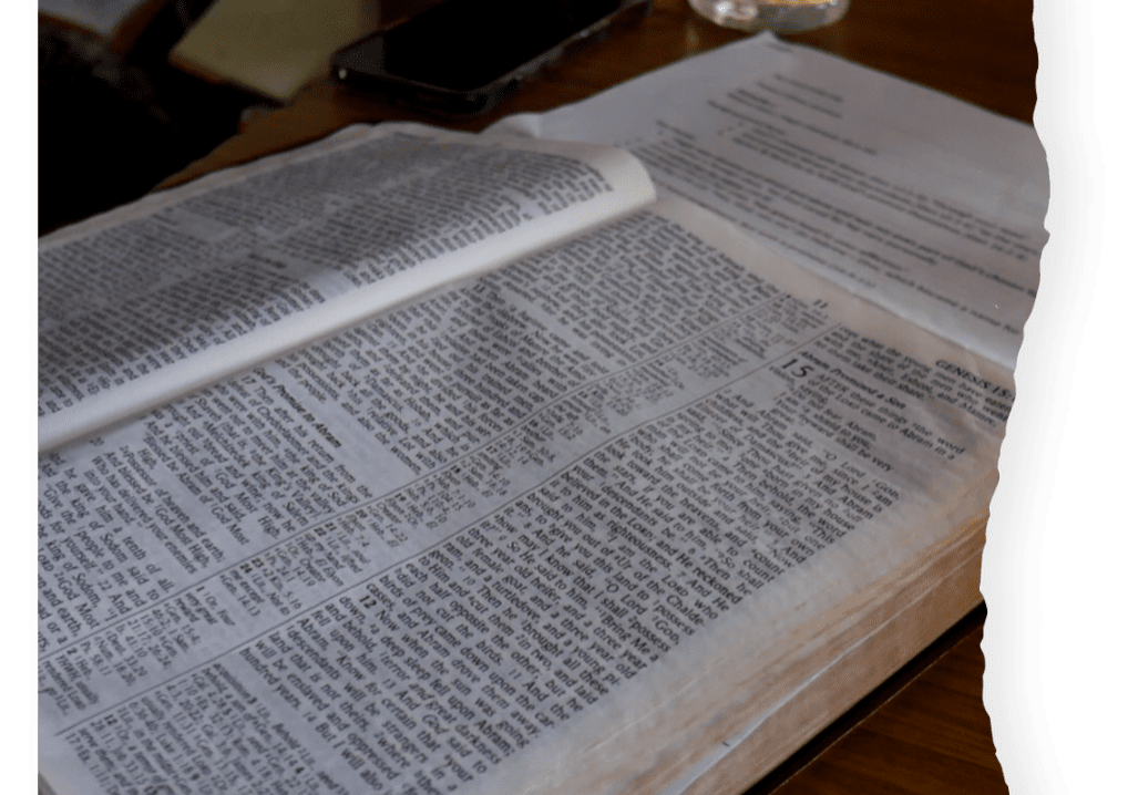 A book is open on the table with a glass of water.