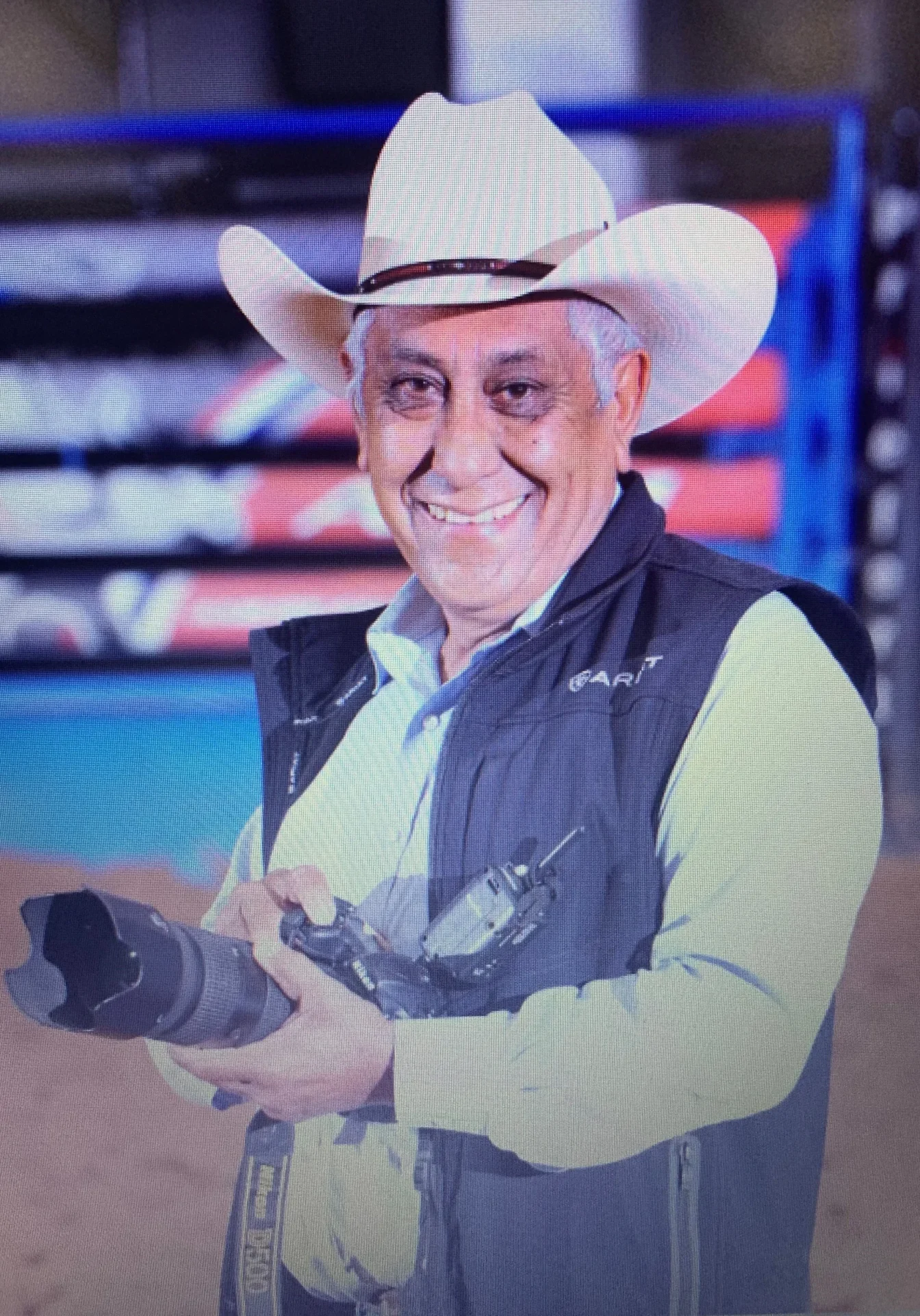 A man in cowboy hat holding a camera.