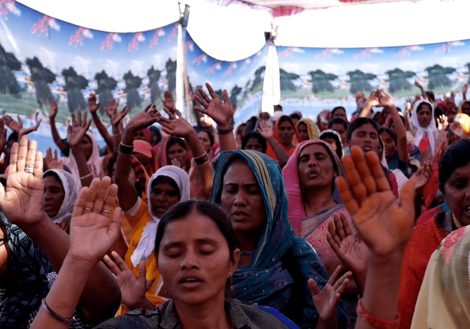 A group of people with their hands raised in the air.