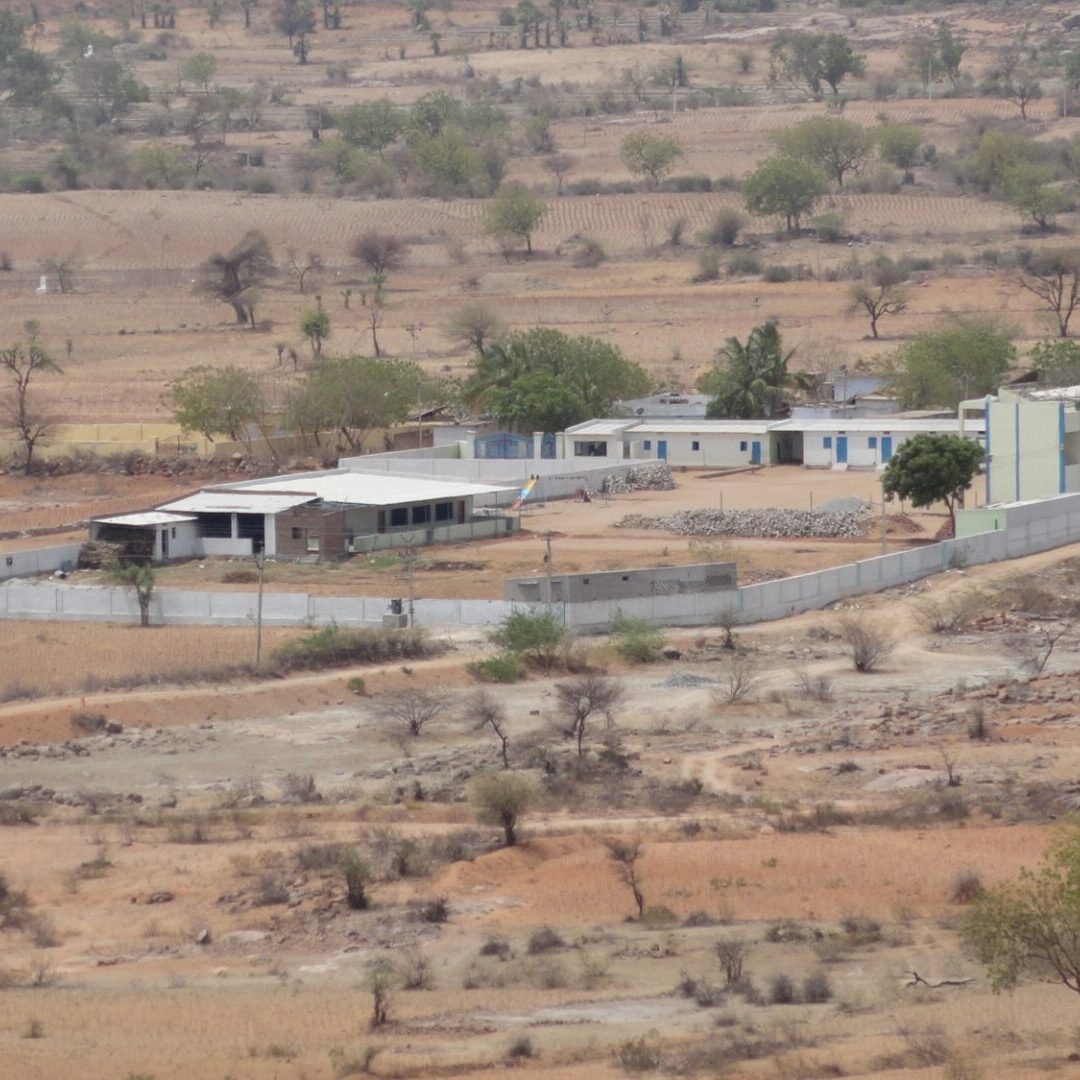 A view of a desert with houses and trees.