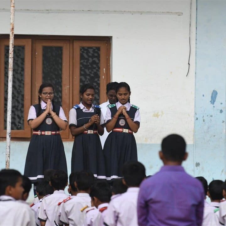 A group of young girls standing in front of a crowd.