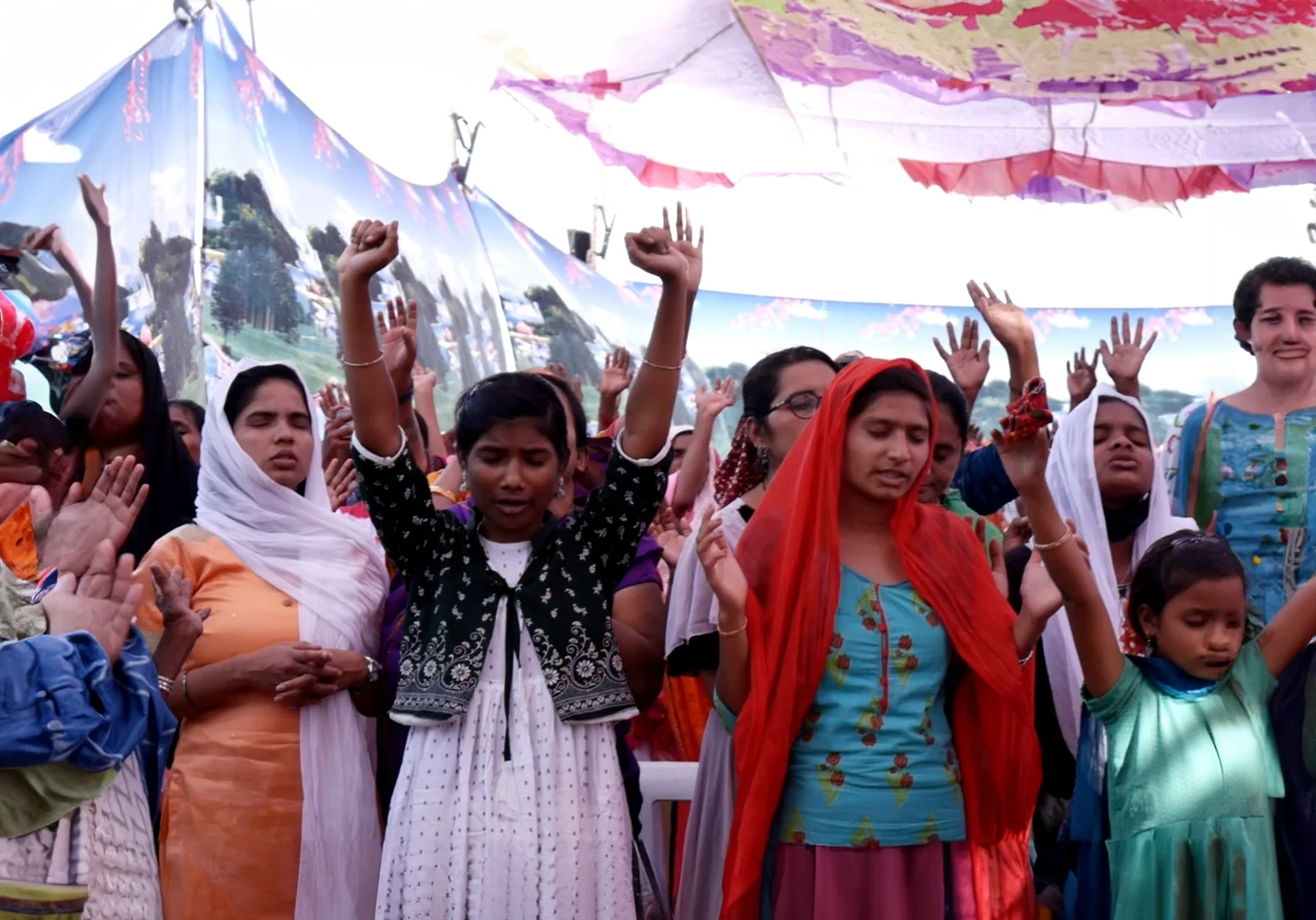 A group of women standing under an awning.